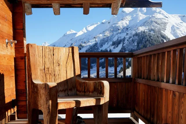 Holzsessel auf einem Balkon mit Bergblick